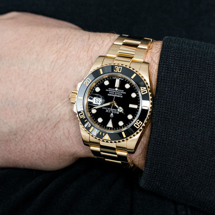 A Rolex Submariner Date 116618LB in 18k Yellow Gold with a Black Dial being modeled on the wrist