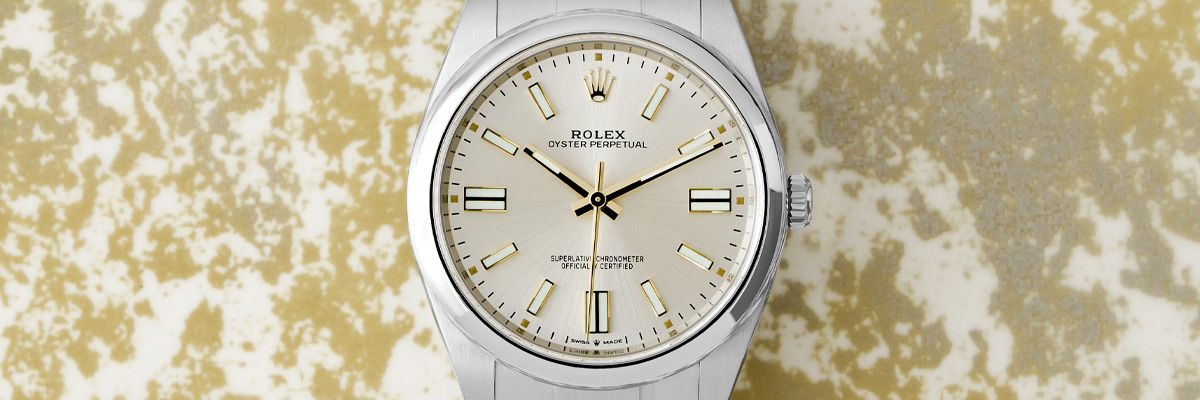 Rolex Oyster Perpetual 36 126000 Wristwatch, Silver Dial The Rolex Oyster Perpetual 36 126000 wristwatch with the Silver dial llaying on a gold and silver table